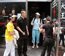 二零零八年六月一日,穿着印有中英文“法轮大法好”和“真善忍”的T恤衫的孙女士(左一)和黄女士(左三)及女儿被法拉盛“十里香菜馆”告知“不服务法轮功”并逐出门外