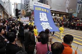 游行队伍张起声援三退的幡旗,道路两旁大批民众在观看。