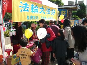 介绍法轮功的摊位上,不时有民众前来了解询问,拿取简介资料