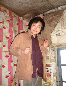 右图被摄于二零一零年,当有人试图接近她时,她就攥着双手躲向自家墙角。(明慧网)