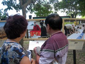 沿着信义广场人行道的法轮功真相图片展,吸引着行人