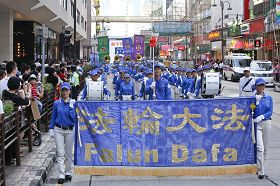 在天国乐团领头下,游行队伍走过繁忙的市区。