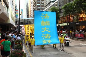 法轮功学员张起“法轮大法好”的大幡,吸引了许多路人的目光。