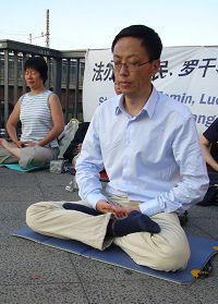 '图片:朱先生曾经亲身经历过一九九九年七月法轮功学员和平上访,被中共警察殴打。而在德国,警察保护法轮功学员的集会。'