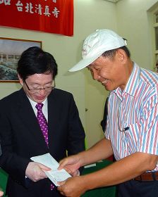 中共宗教局长王作安(左)在拜访台北清真寺后,收到法轮功学员(右)送的诉状,王认为是礼物,道谢收下。