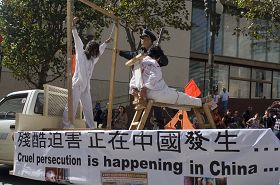 演示中共残酷迫害法轮功的酷刑展车,并呼吁善良的人们伸出援手共同制止迫害
