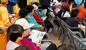 '来参加当天活动的市民接收法轮功传单了解真相,并在声援法轮功反迫害的签名栏上签名。'