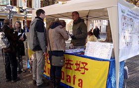 信息台前,游客在了解法轮功真相