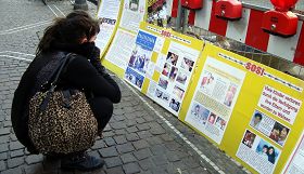 这位法国女游客,蹲在这里看真相展板已经有半个小时了