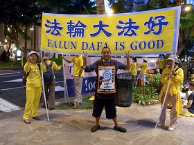 在威基基(Waikiki)街上打工发传单的Andrew明白法轮功真相后,和学员一起向经过的中共官员高喊“法轮大法好”、“停止迫害法轮功”。