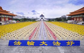 '亚洲法会召开前夕,来自台湾各地、日本、韩国、新加坡等十个国家以外,还有澳洲、新西兰及美国等七千多人在台北自由广场集体炼功,壮观宏大的场面吸引许多游客。闪光灯不停的拍拍响着。'