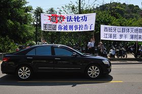 “你被刑事控告了”——安徽省省长王三运四月二十日上午至桃园县桃园铭传大学时,车队在校园路前看到法轮功学员的抗议横幅