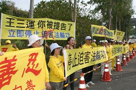 台南市议员曾秀娟(左三)声援法轮功,一起拉横幅对王三运大声呼口号。
