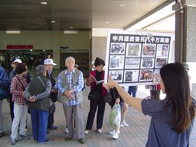 游客观看展板,或阅读真相资料
