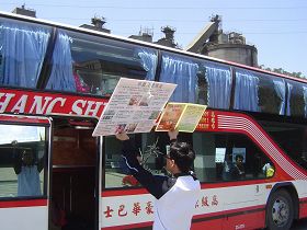 游客坐上游览车后,依然目不转睛注视着真相展板