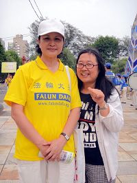 卓小姐(右)竖起大拇指支持法轮功学员。