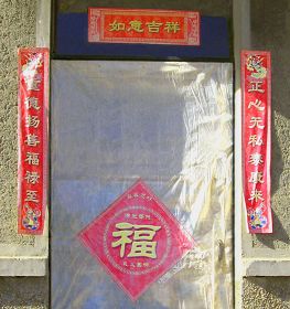 大棚不远处的平房,门上的对联历经风雨日晒,依然醒目:重德扬善福禄至 正心无私泰康来。大门的福字顶端写着“真善忍好”。