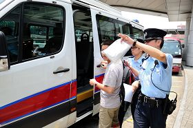 涉嫌在红磡火车站指使大陆小学生进行破坏的一名男子被警方拘留,带上警车。