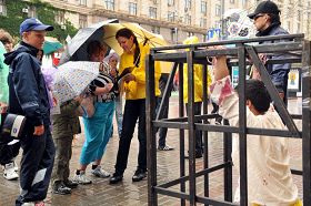 揭露中共暴行的模拟酷刑展前,人们纷纷签名反迫害