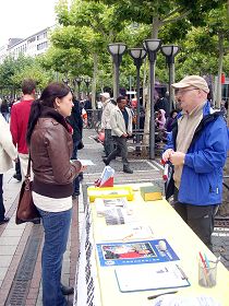 多米尼克(右)向民众讲法轮功真相