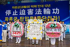 '二零一一年七月十六日,韩国八大市民团体与法轮功学员冒雨在首尔广场举行联合集会,谴责中共对法轮功长达十二年的人权迫害。图为现场展示被中共迫害致死的中国法轮功学员。'