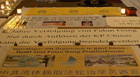 横幅和图片,向人们讲述着修炼“真、善、忍”的法轮功学员在中国无辜遭受的迫害