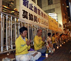 法轮功学员在中联办正门外点起烛光,悼念被迫害致死的中国大陆同修。