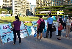 七月二十日下午,各国游客观看韩国法轮功学员在首尔广场展出的真相展板。