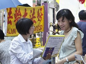 退党义工阿媚(左)在旺角街头劝大陆遊客退出中共相关组织