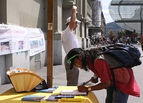 瑞士首都伯尔尼火车站广场上,路人签名声援法轮功反迫害