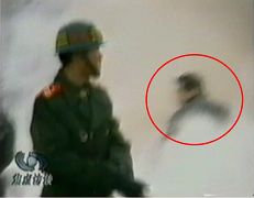 CCTV“自焚”节目慢动作分析-4:一名身穿大衣的男子正好站在出手打击的方位,仍然保持着一秒钟前用力打击的姿势