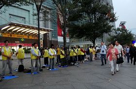 台湾法轮功学员长期在台湾各景点讲真相及洪法,图为大陆观光客观看法轮功学员在台北一零一大楼前炼功。