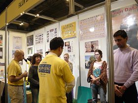 在法轮大法展位上,不断有参观者前来学炼五套功法