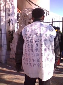 周向阳的老父亲身着状衣站在滨海监狱门口,等待监狱能尽快答复。