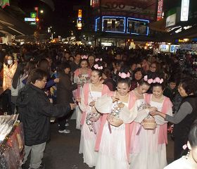 法轮功学员组成的仙女队伍深受市民的喜欢,大家争先恐后领取系有小莲花的“法轮大法好”书签