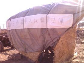 '草棚面对监狱大门打出的横幅:尊重生命 尊重人权 尊重法律'