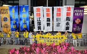 法轮功学员在中联办门前,张起法办江、罗、刘、周等迫害元凶的幡旗,并宣读声明