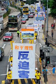法轮功学员张起“和平理性反迫害”的大幡,行经香港的主要金融经济区。