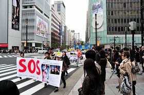 日本法轮功学员游行纪念“四•二五”,经过东京繁华街头,许多市民驻足观看