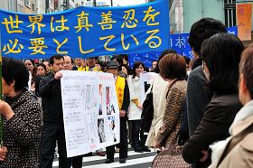 日本法轮功学员游行纪念“四•二五”,经过东京繁华街头,许多市民驻足观看
