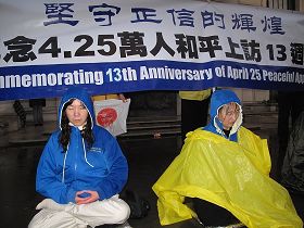 风雨中,法轮功学员坚持在伦敦中使馆前反迫害,传真相