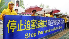 韩国法轮功学员金秀宏(右一)四年来不畏风雨在出入境管理事务所前传播法轮功真相