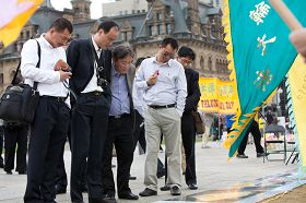 中国旅游者在展板前驻足,了解法轮功真相