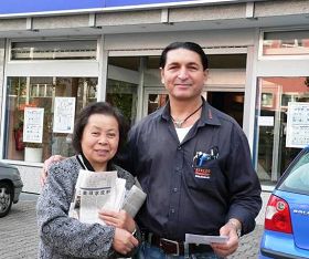 这位学员(左)每天坚持在中领馆前发真相资料,使在附近工作的人们知道了法轮功真相