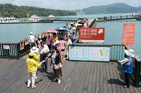 '法轮功学员在码头上给游客派发资料,传播法轮功真相'
