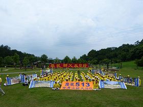'中坜全体学员于十二日上午在大溪慈湖纪念雕塑公园合影,并向李洪志师父问候生日好。'