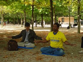 '艾力(右)和同修在公园里打坐炼功'