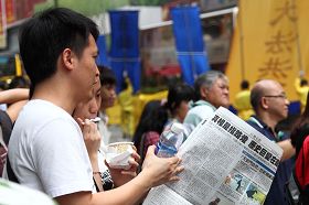 学员们派发的真相资料大受欢迎,民众一边观看游行,一边阅读特刊