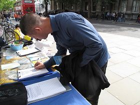 初遇法轮功的法国人约翰立即决定要学炼法轮功,并在反迫害征签表上签名