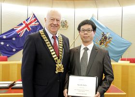 市长(左)在市政府议员会议上为法轮功团体代表颁奖